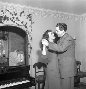 Dancing in the 1950s. A couple at home is dancing to music from their radio reciever. Photo Kristoffersson Ref BF58-8. Sweden 1952
