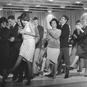 Dancing in the 1960s. The dance Hully Gully is being made popular and here are men and women dancing the new craze. Hully Gully was a type of unstructured line dance and consisted of a series of steps and was relatively simple and easy to execute