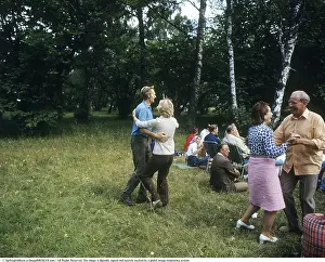 Dancing in the 1970s. Its a summer day and the dancing take place outdoors on the grass