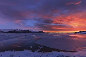 Dawn over frozen lake and mountains