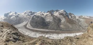 At dawn, the sun bathes the peaks of the Alps in a golden light and reveals stunning glaciers and rocky slopes