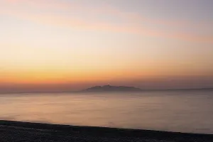 Dawn at sunrise, view from the lava beach near Kamari to the island of Anafi