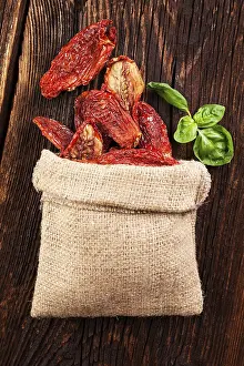 Delicious dried tomatoes on brown wooden vintage textured background