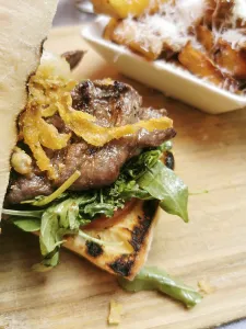Delicious sandwitch with cooked slices of pork steak onions and vegetables