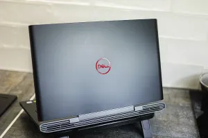 Dell laptop with red logo placed on a desk in home office setup