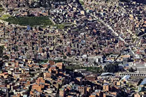 Dense urban development with many brick buildings in hilly surroundings