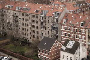 Dense urban scene with red tile roofed residential buildings under an overcast sky in Aarhus