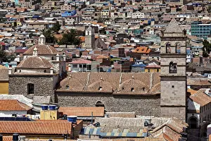 Densely built-up city scene with brick towers and colonial architecture in the foreground