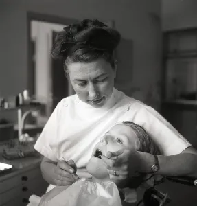 At the dentist in the 1940s. A boy is being examined and treated by a dentist