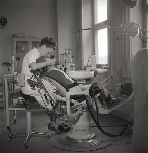 At the dentist in the 1940s. A boy is being examined and treated by a dentist