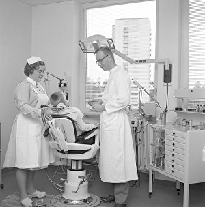 At the dentist in the 1960s. A boy is being examined and treated by a dentist