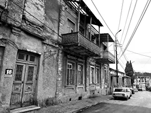 Deserted street with old, dilapidated buildings and a nostalgic parked classic car