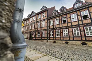 Detailed half-timbered buildings along a cobbled street on a cloudy day