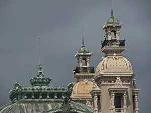 Detailed view of architectural towers and domes in front of a cloudy sky