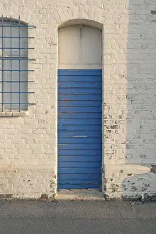 Category Historic EN Prints: Detailed view of an old blue weathered long hall door in the evening light
