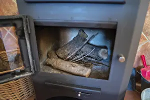 A detailed view of an open wood burning stove filled with logs