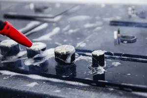Detailed view of soap-covered stove knobs being cleaned with spray