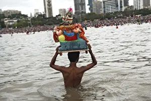 Devotee carrying idol of god ganesh for immersion in girgaum chowpatty