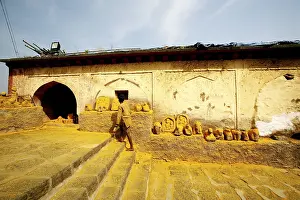 Devotee paying respects to statues immersed in turmeric powder at Jejuri temple