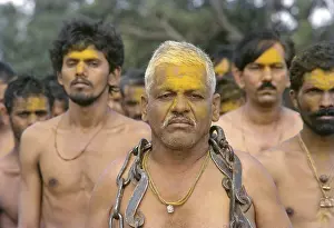 Devotees stripped to the waist waiting to be possessed by Khandoba stand in the river