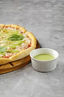 This dish features a freshly baked pizza with a golden crust adorned with toppings like fresh greens