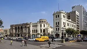 Distinctive historic buildings at a busy crossroads under blue skies