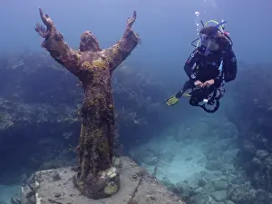 Category Coral Reefs DE Prints: Diver looking at the statue of Jesus Christ underwater (Christ of the Abyss)