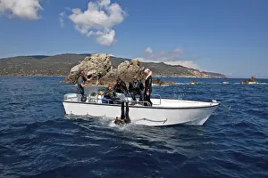 Divers drop backwards over side of dive boat small dive boat into water