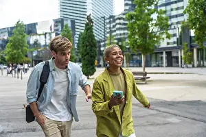 Diverse business colleagues walking on a paved pathway outdoors in a modern city district