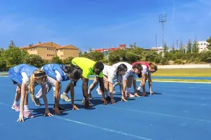 Diverse group of athletes ready to start a race on a blue running track