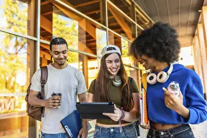Diverse group of young students walking together on a vibrant university campus