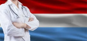 Doctor with crossed arms on Luxembourg flag