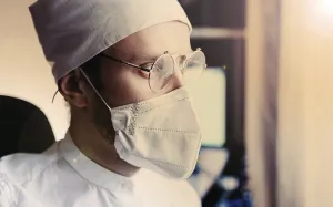 Doctor in mask and glasses, basked in warm sunlight