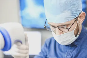 Doctor in medical attire focused on equipment