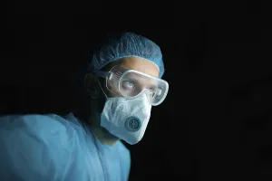 Doctor in protective gear with goggles and mask
