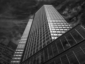 Dramatic black and white view of a modern tower block under a cloudy sky
