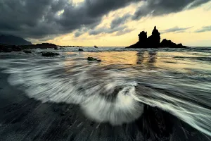 Dramatic cloud atmosphere with rock formation at sunset on the beach of Playa de Benijo