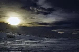 Dramatic snowy landscape at sunrise with mountains in the background