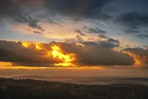 A Dramatic Sunset in the Evening with Clouds over a Valley in the Forest