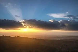 A Dramatic Sunset in the Evening with Clouds over a Valley in the Forest