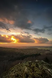 A Dramatic Sunset in the Evening with Clouds over a Valley in the Forest