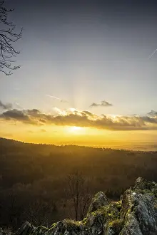 A Dramatic Sunset in the Evening with Clouds over a Valley in the Forest
