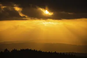 A Dramatic Sunset in the Evening with Clouds over a Valley in the Forest