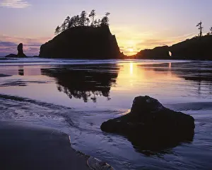 A dramatic sunset silhouettes a sea stack at Second Beach in Olympic National Park