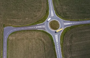 Drone image, roundabout with lorries between harvested fields