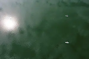 Drone shot, from above, sun reflection in the water with stand up paddler at the Irrsee