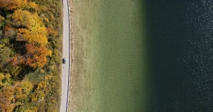 Drone shot, Austrian Romantic Road along the Mondsee near Pichl Auhof with autumnal deciduous forest