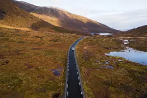 Drone shot, campervan on a road with autumnal vegetation