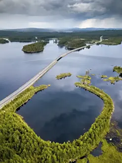 Drones shot, winding road runs through lake landscape