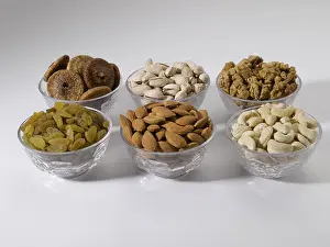 Dry fruits and nuts, almonds pistachios walnuts raisins figs cashew nuts in bowls